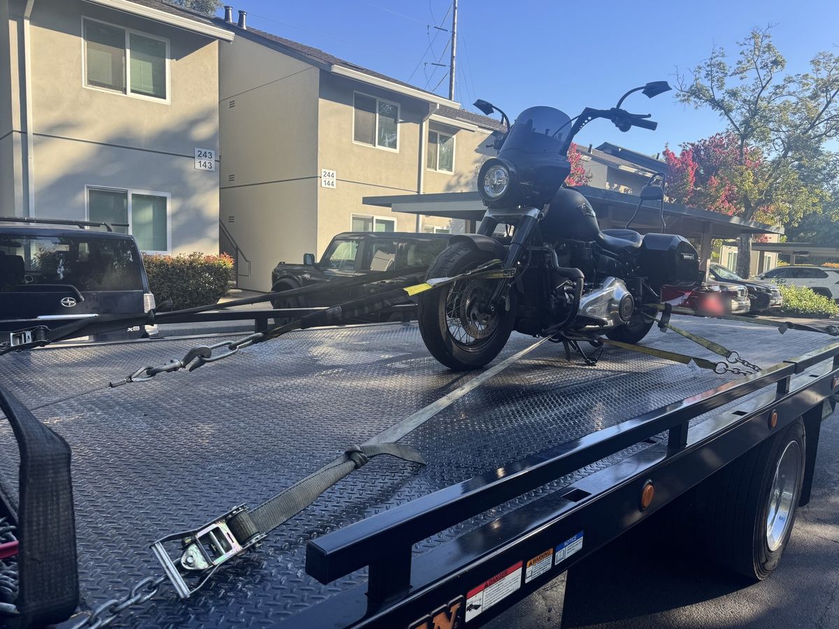 Motorcycle strapped down on a flatbed tow truck